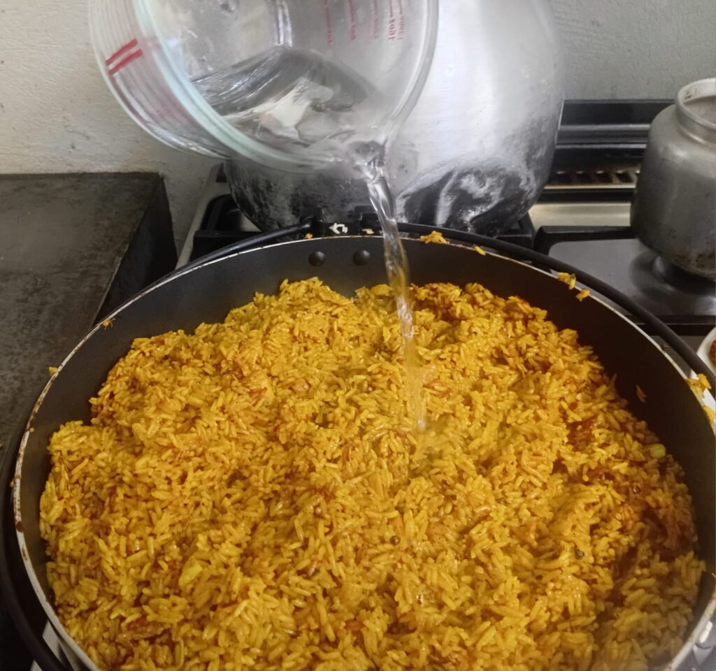 Reis umrühren und Wasser hinzugeben